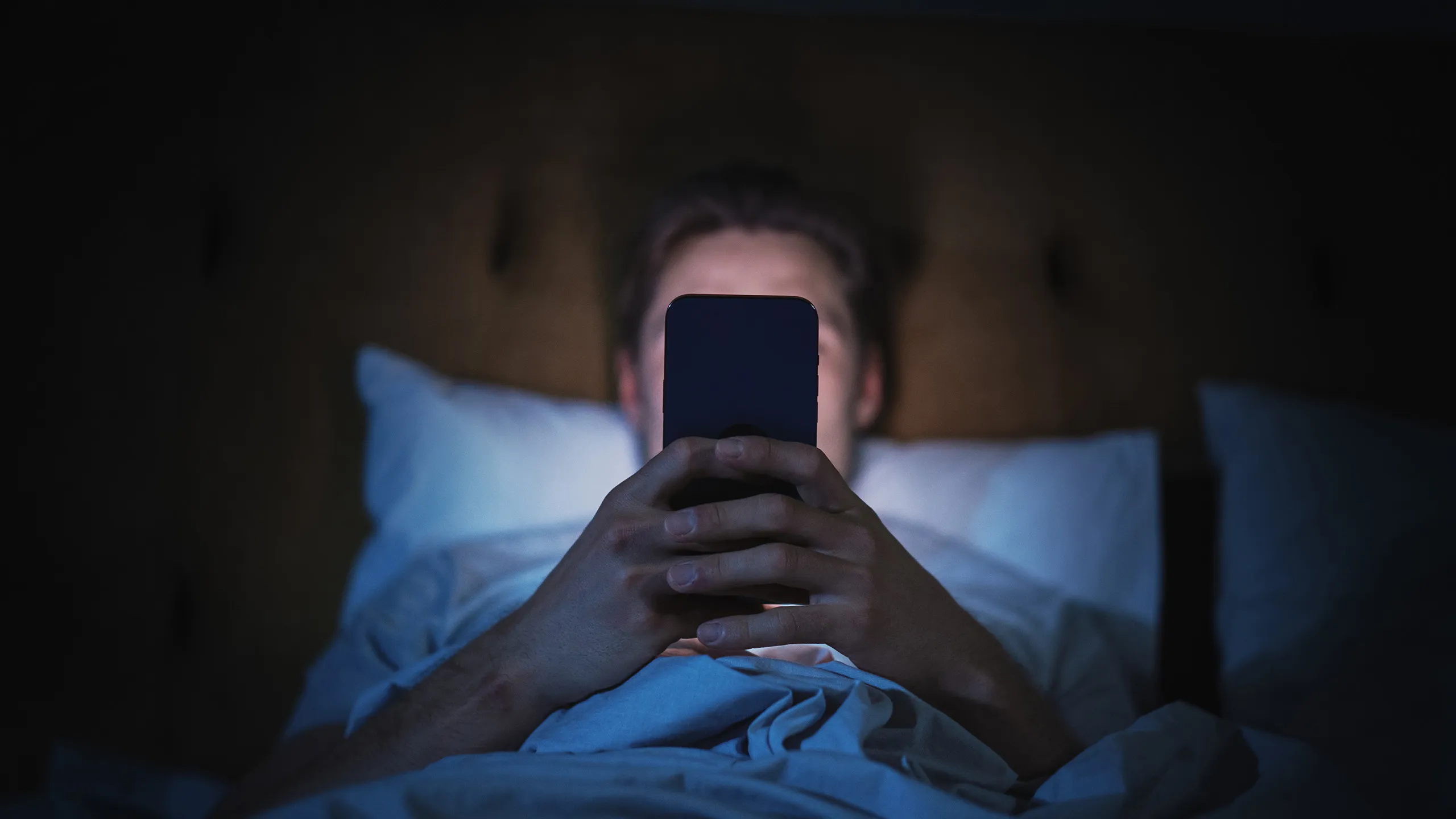 Person in bed looking at their phone